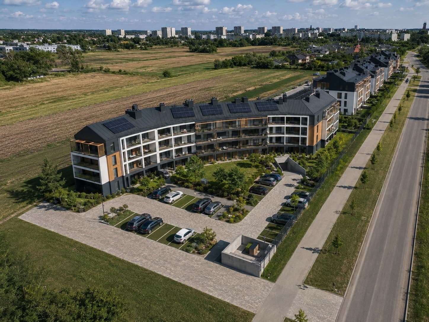 Budynek D osiedla Nowe Winiary z lotu ptaka, w tle zabudowa Gniezna