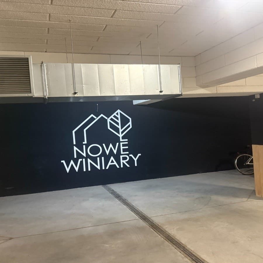 Hala garażowa z logo Nowe Winiary na ścianie